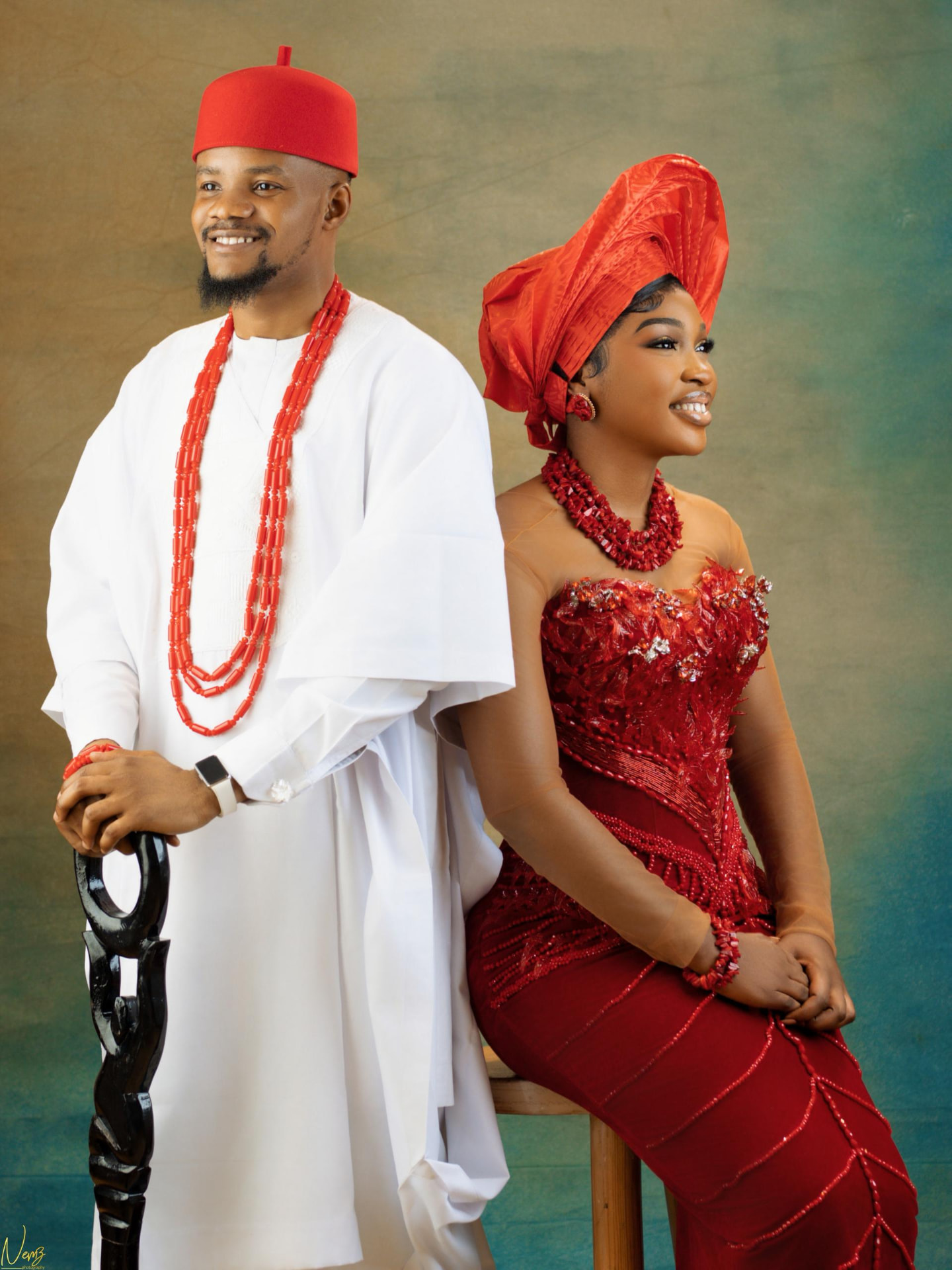 Kent and Iheoma back to back in traditional attire, both smiling away from camera